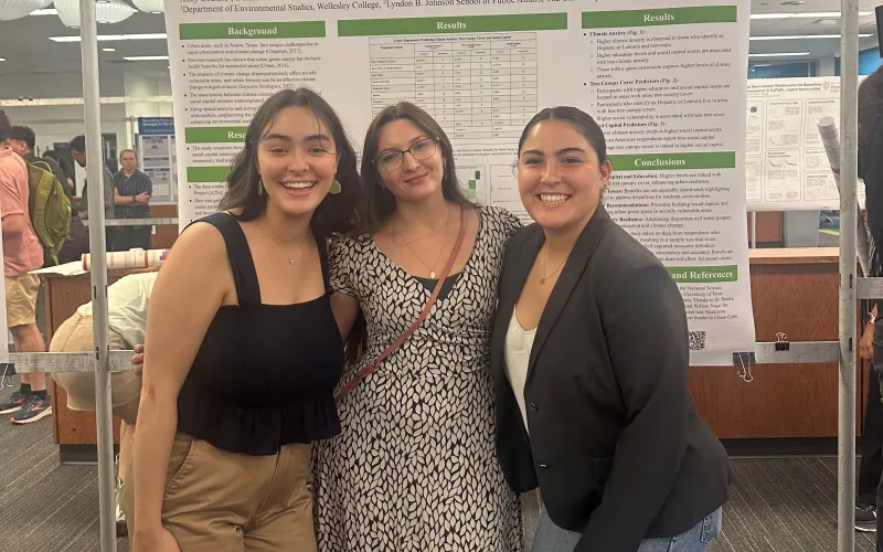 three people in front of a research poster